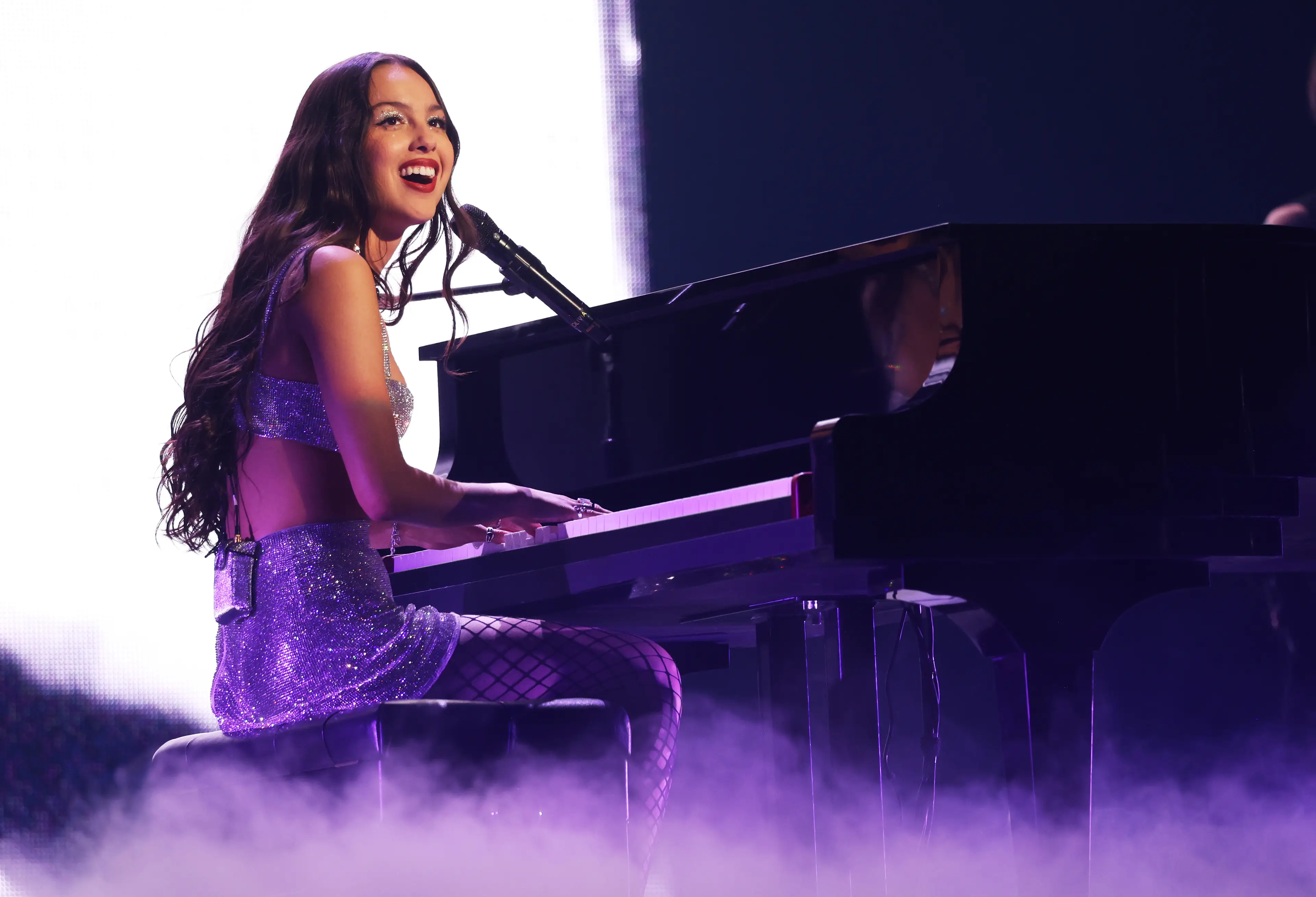 Olivia Rodrigo Toca Boca promo with retro cassette player and May 12 to June 8 event dates on pink and yellow background